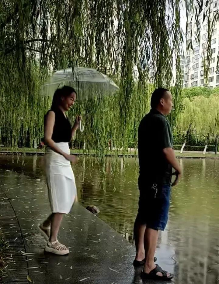 雨中漫步，情侣相依，浪漫且悠然。湖水澄澈，垂柳似丝，环境宜人，心情愉悦。苍天眷顾