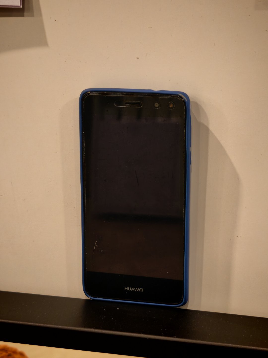 巴塞罗那酒店一楼，用双面胶粘了一排手机。看看你能认出几个？都是正面，确实不好辨别