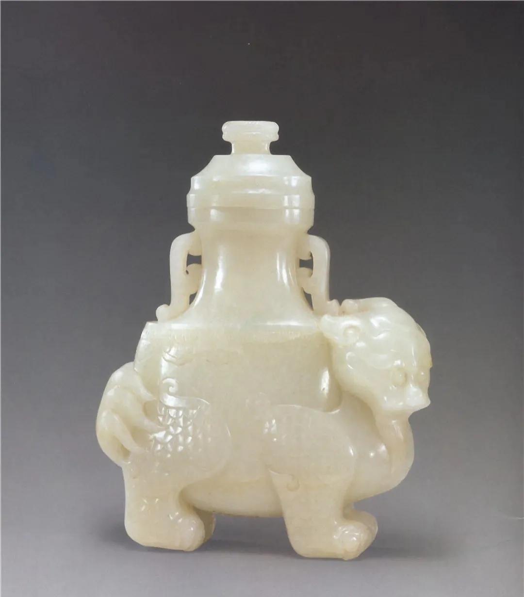 通高13cm，该器仿自古代盛酒的一种青铜器。青白玉。独角神兽圆目大口，背驮一壶，