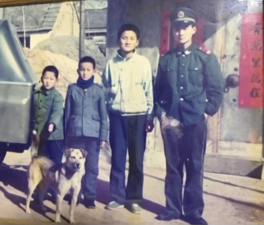 这张老照片应该是拍摄于九十年代，里面的人都非常优秀帅气，但图中左下角的土狗（我们