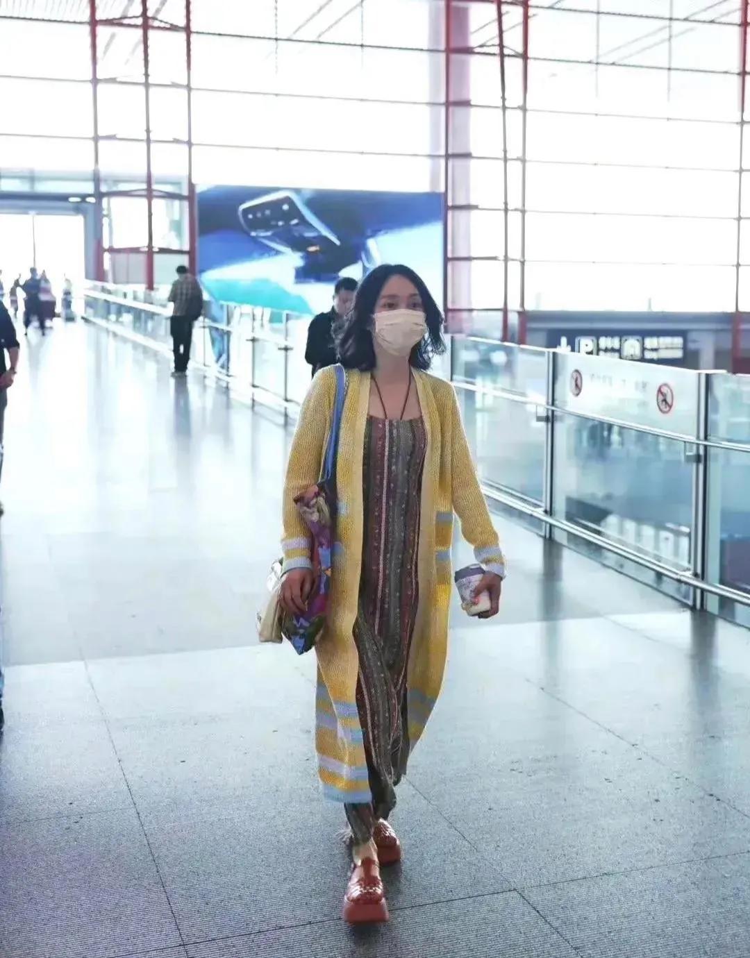 周迅似乎和时尚圈无缘啊！
周迅外穿鹅黄色披风款针织开衫，内搭彩色绸缎式条纹长裙，