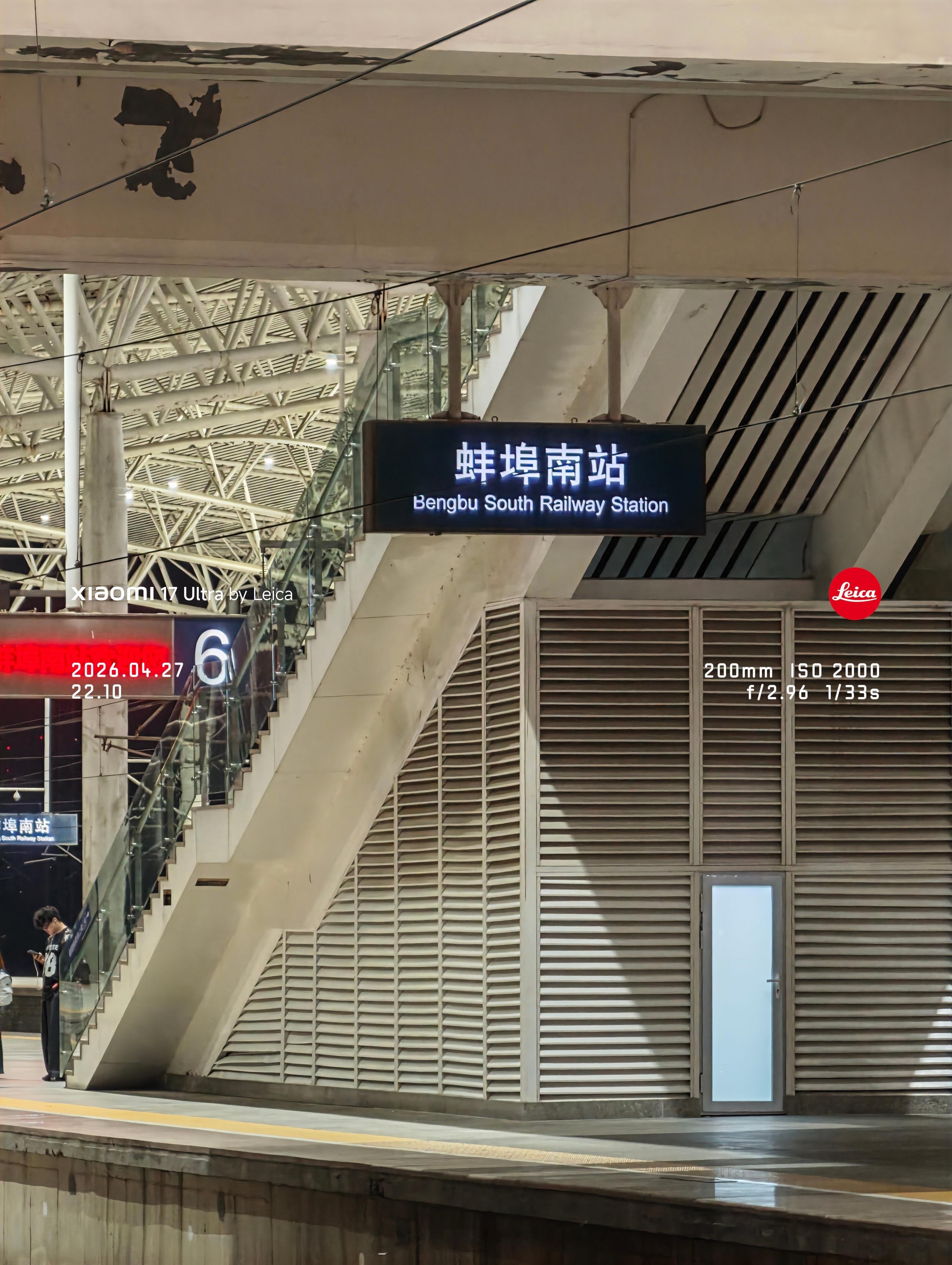 下扶梯前顺手拍一张。空无一人的展台夹杂着一丝雨后的泥泞，广播里喊着未出站的旅客请