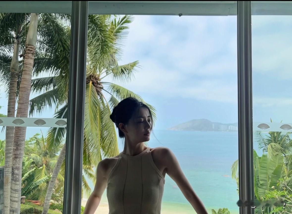 徐璐海边度假照，身穿背心和牛仔裤，整个人薄薄的一片，手臂又长又细，目测也就80来