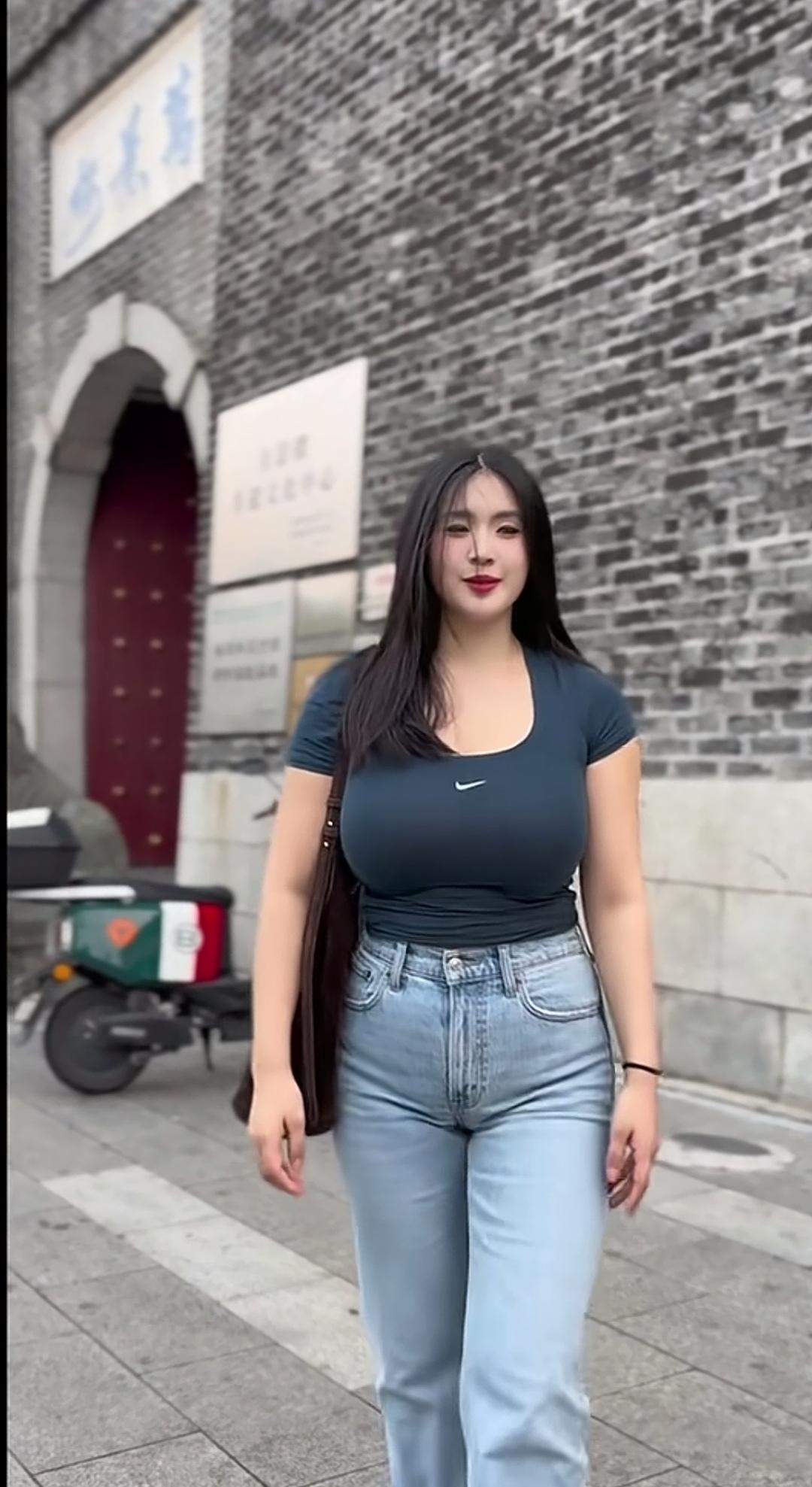 妹子穿牛仔裤走在街上。