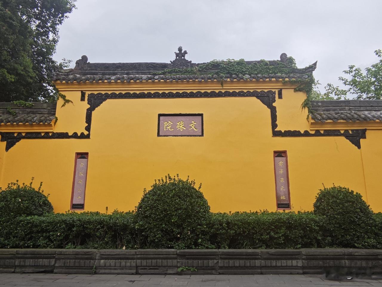 浣溪沙3·成都文殊院
赭壁明黄映古垣，
藤痕漫上旧檐端。
禅门静锁一城烟。
树拥