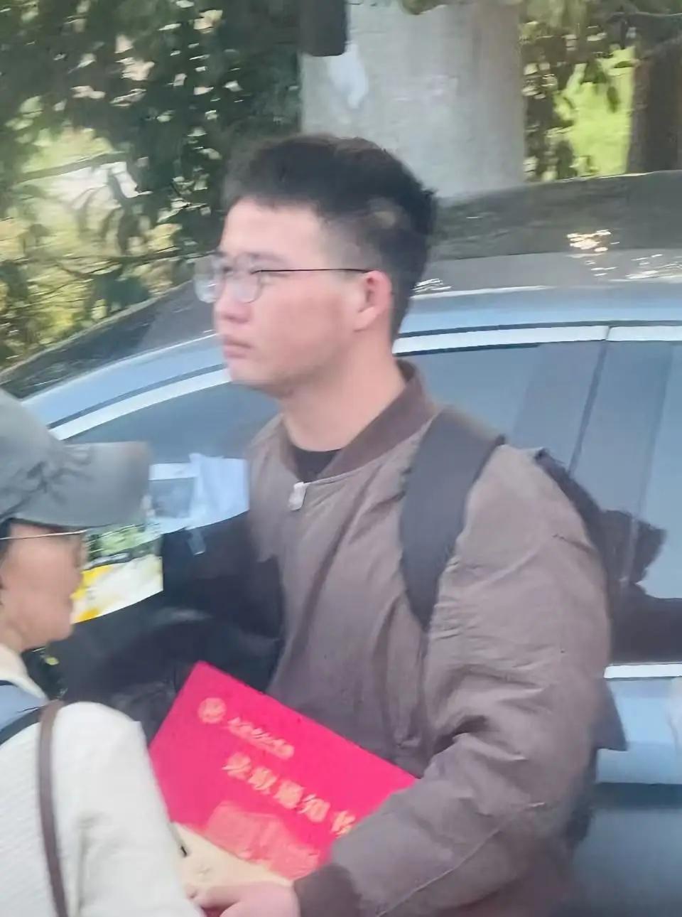 那一抹炽热的红，本应是青春最耀眼的底色，此刻却在肃穆的黑白灰中，显得格外沉重。人