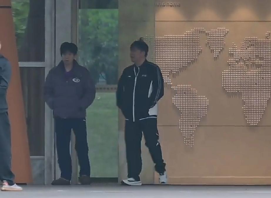 今天一大早，在成都国乒训练基地，出早会的王楚钦。与教练一起下楼后等男队队员汇合。