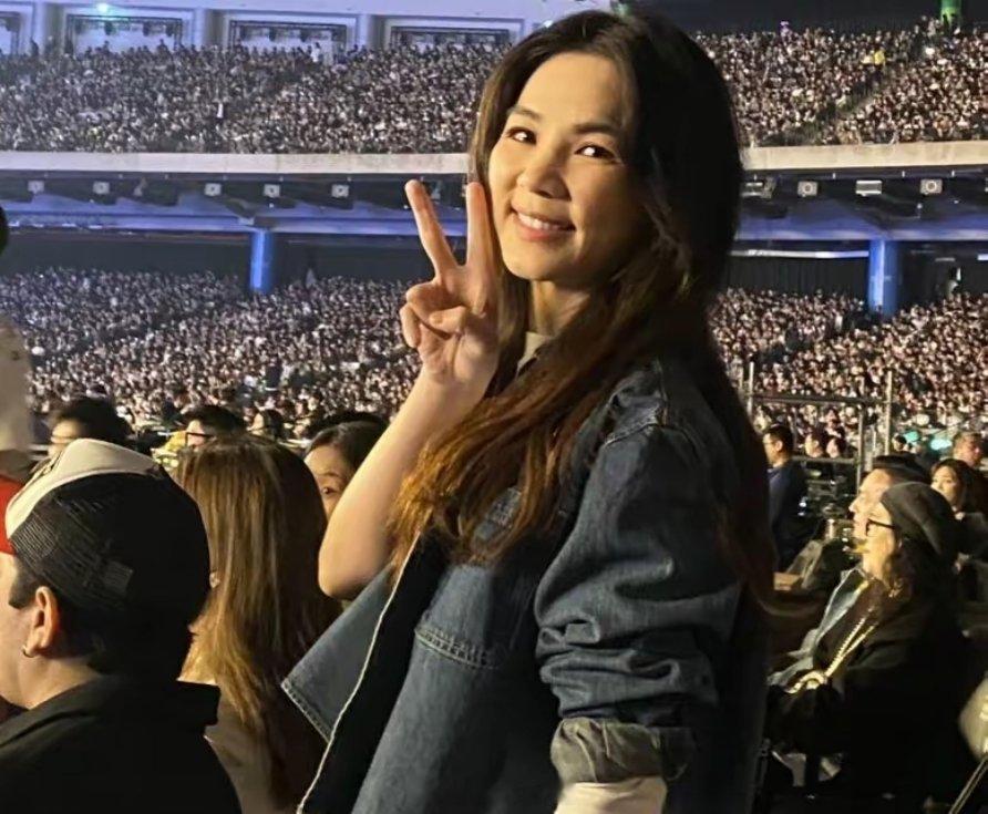 Ella一头长发，身穿牛仔服，素颜装扮，看起来精神很好，带着孩子与老公一起来看演