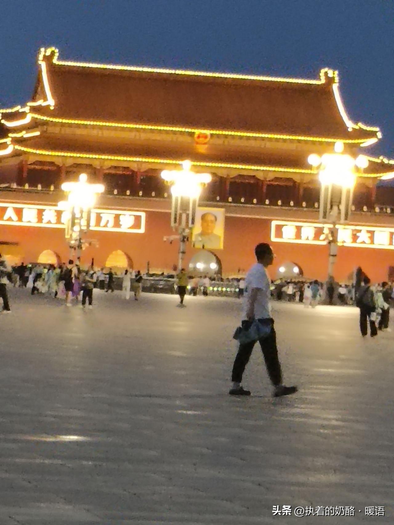 夜幕下的天安门广场，灯火辉煌，小雨下来观看降旗仪式的人潮涌动天安门周边夜景