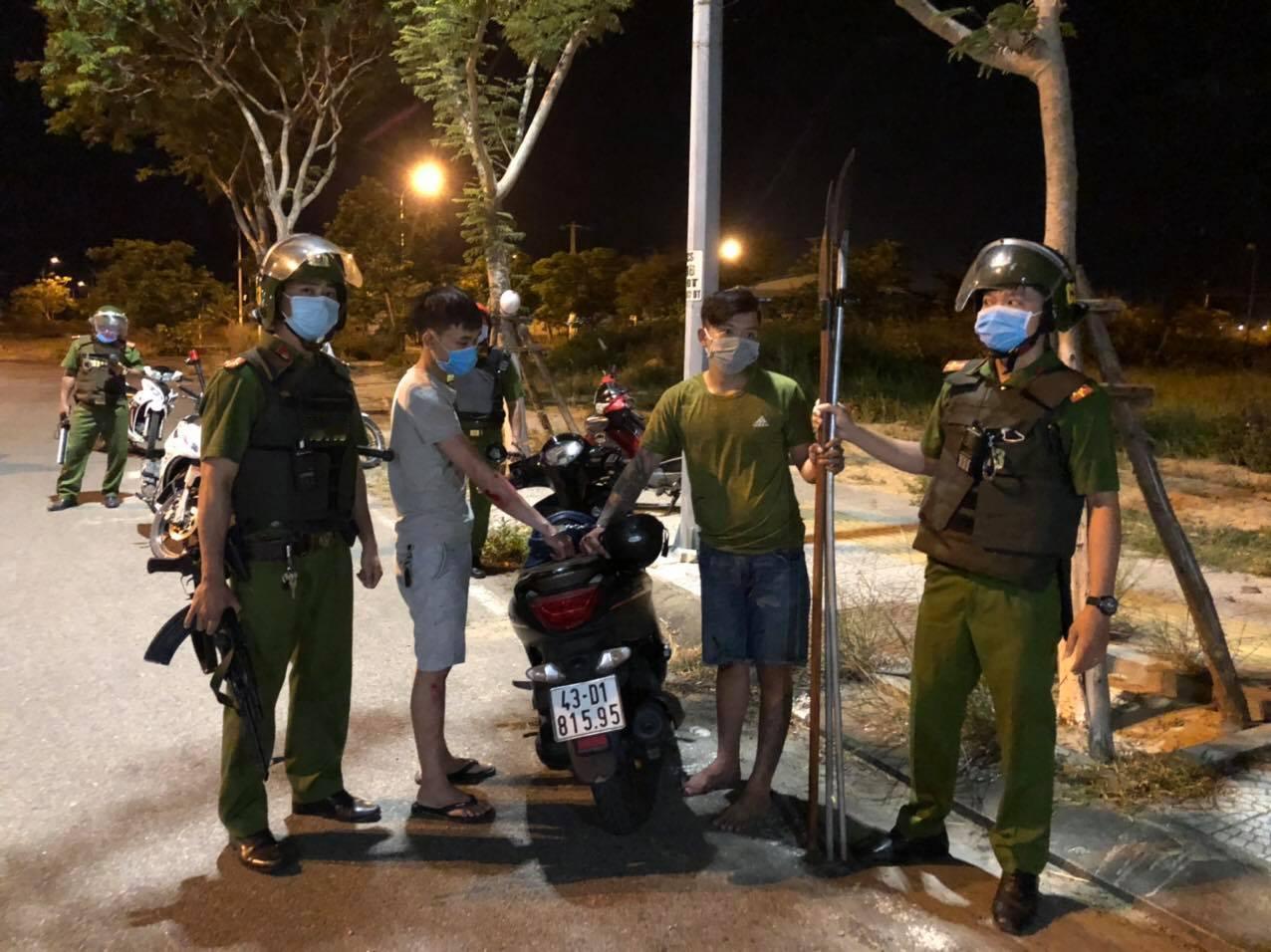 越南公安与抓获的两个骑摩托拿长刀的青年