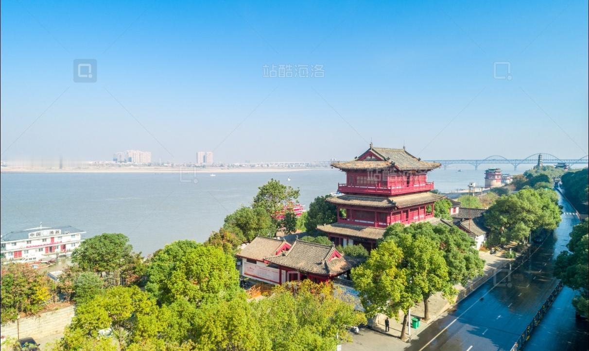 浔阳楼临江而立，青甍黛瓦、飞檐翘角，仿宋风骨凛然。登楼凭栏，长江奔涌东去，大桥横