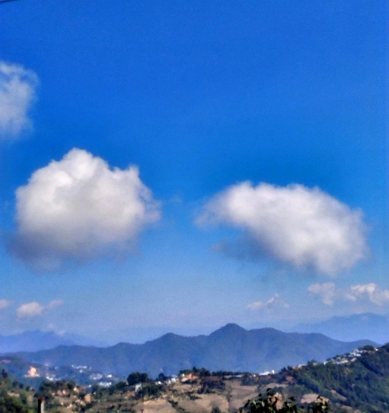 蓝天白云下的山丘，宁静而美丽。