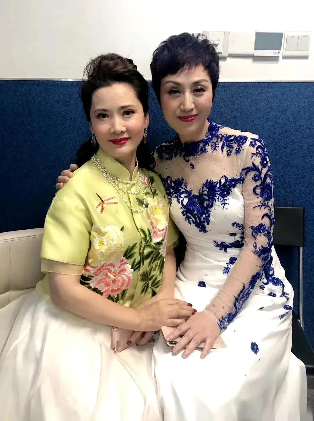 两大美女同框真的太养眼了，何赛飞身着一袭鲜嫩亮丽的黄果绿色真丝缎绣小衫，搭配白色