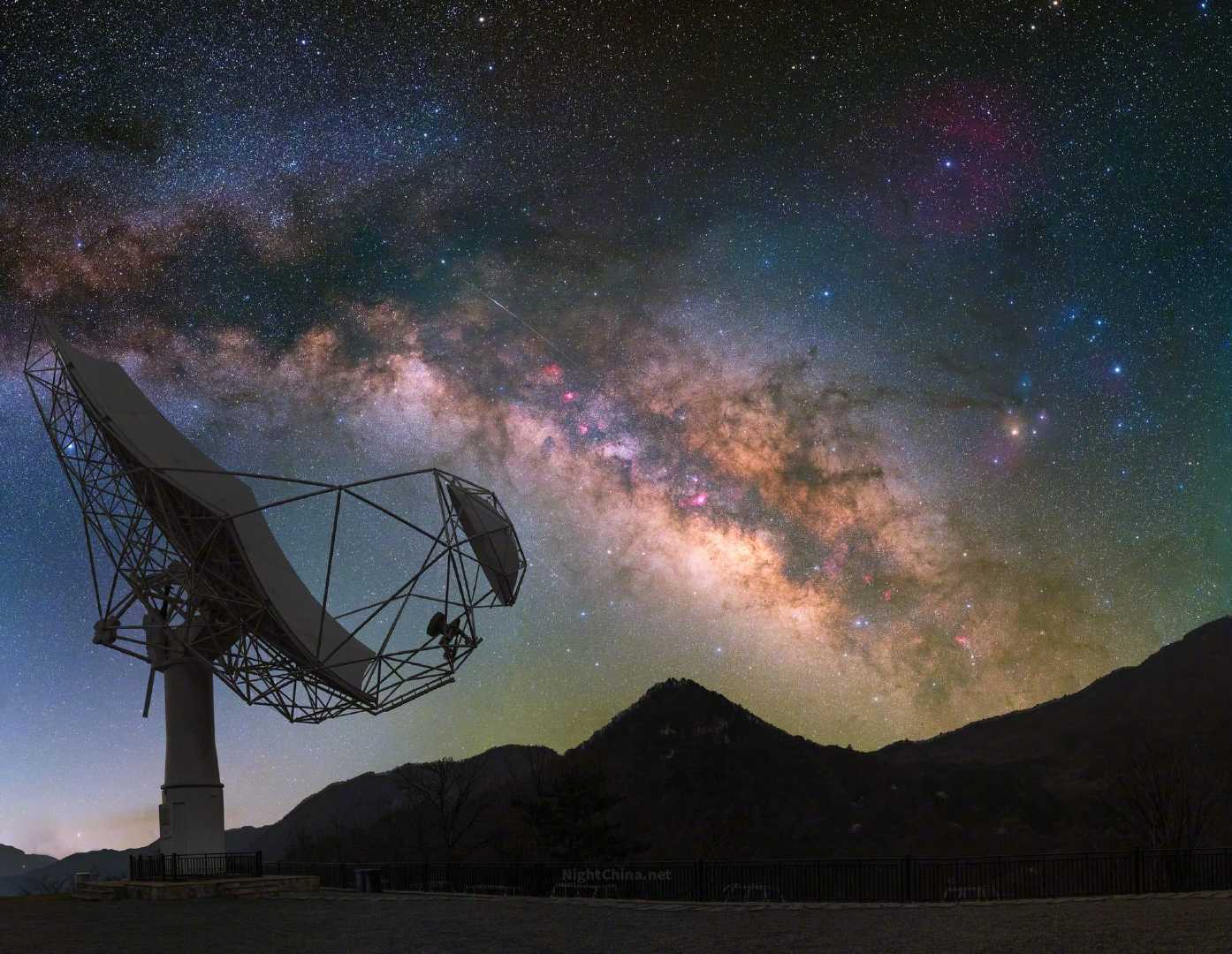 银河在山脊上方慢慢浮现，像是赴一场久别的约定。朝向星河侧身而立的射电望远镜，形似