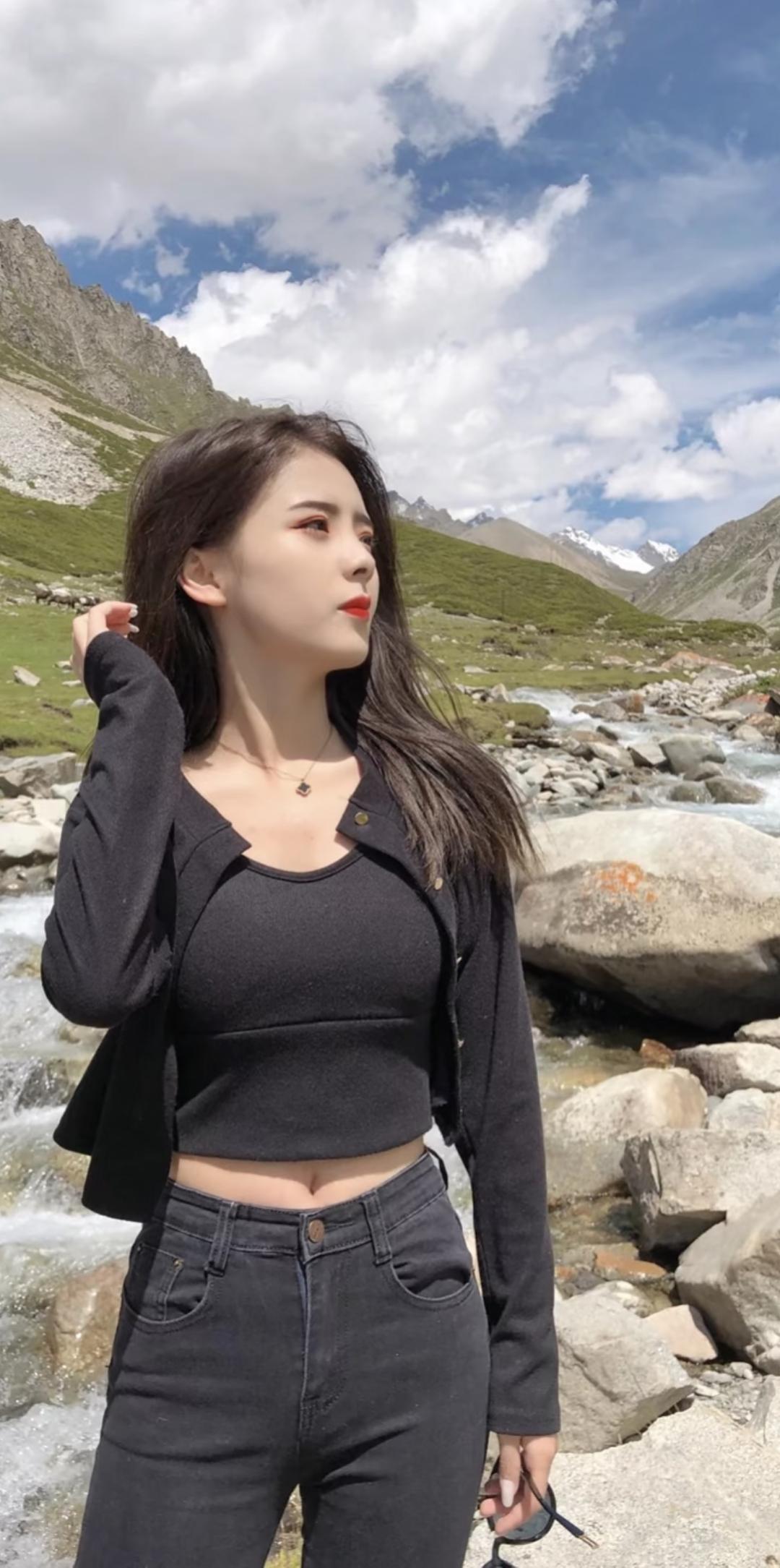 山间小溪边，黑衣美女，红唇轻启，自然与时尚的完美融合。