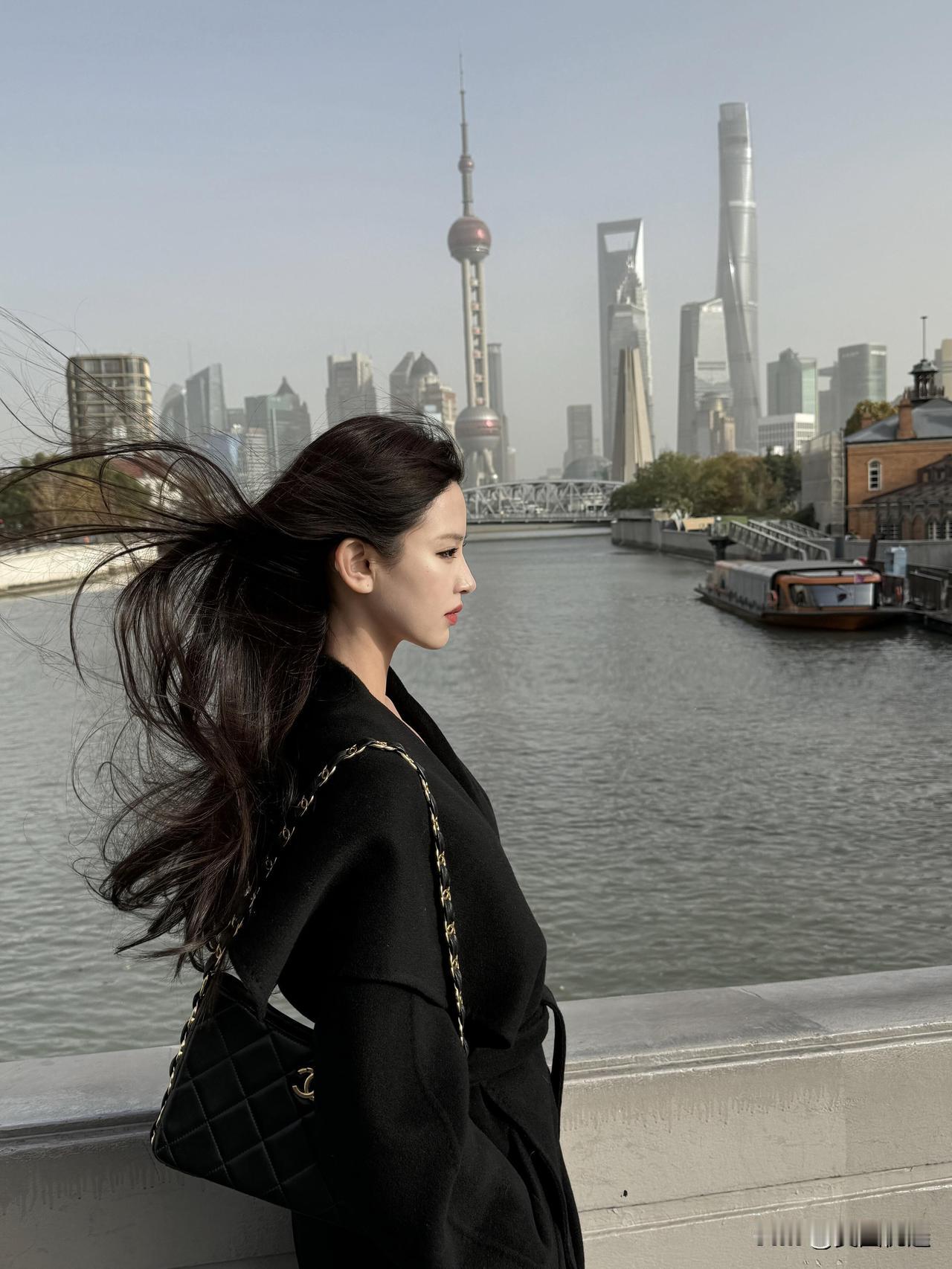 上海外滩的时尚少女，风中飘逸的秀发与现代都市背景相映成趣。