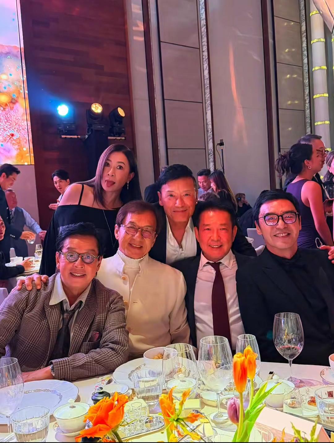 一群朋友在宴会厅开心合影。这位女士有认识的吗？他们年龄都不小了吧？你们全认识吗？