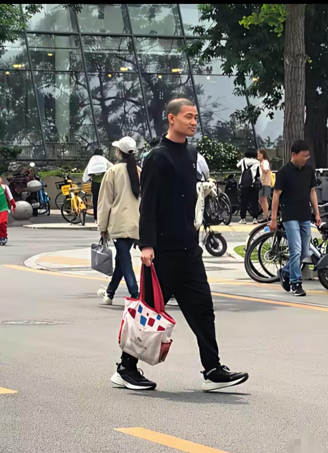 韦神来了，黑色上衣，黑色裤子，黑色运动鞋，这身穿着比以前利落多了，还有手里拎的白