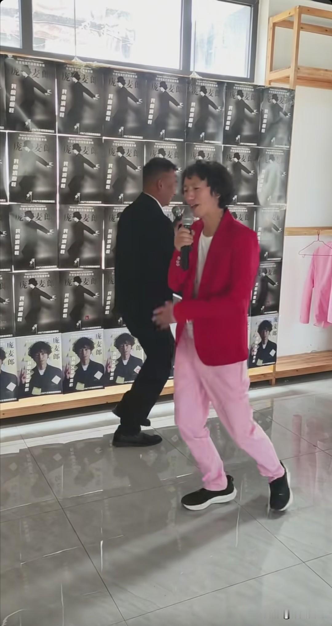 背后全是巡演宣传图片，随着《我的父亲是瓦匠》节奏一响，国际巨星庞麦郎带着粉丝一起