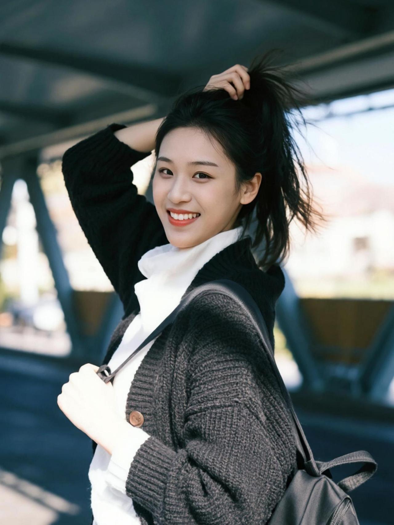 黑色外套搭配浅色内搭，简约中透着时尚感，仿佛是秋日街头的一抹亮色。随意扎起的头发