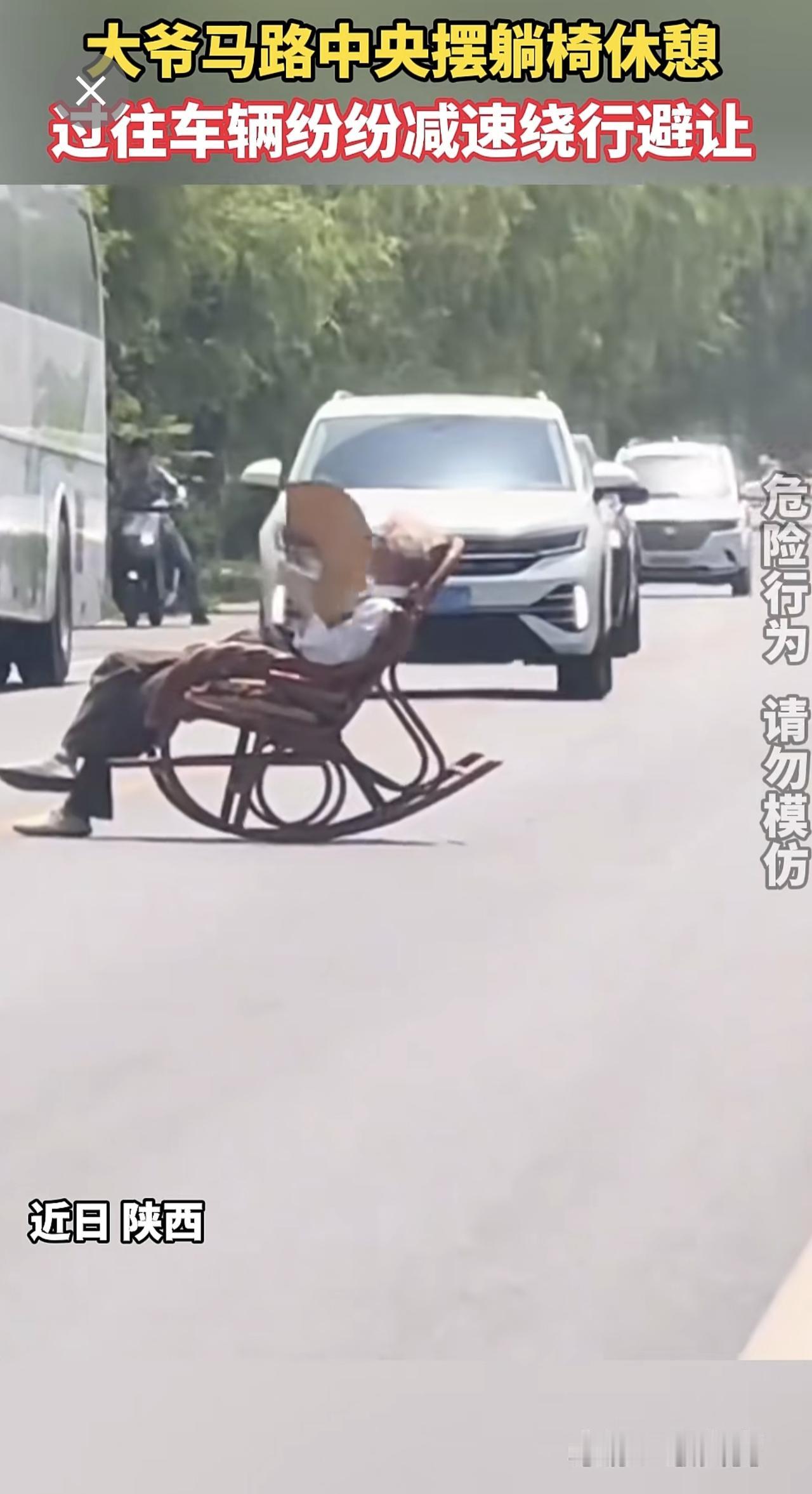 大爷马路中央摆躺椅休憩，过往车辆纷纷减速绕行避让。