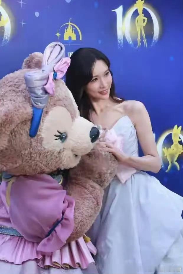 上海迪士尼十周年请了林志玲6月15日盛典红毯，她一袭白色抹胸公主裙，牵着雪莉玫登
