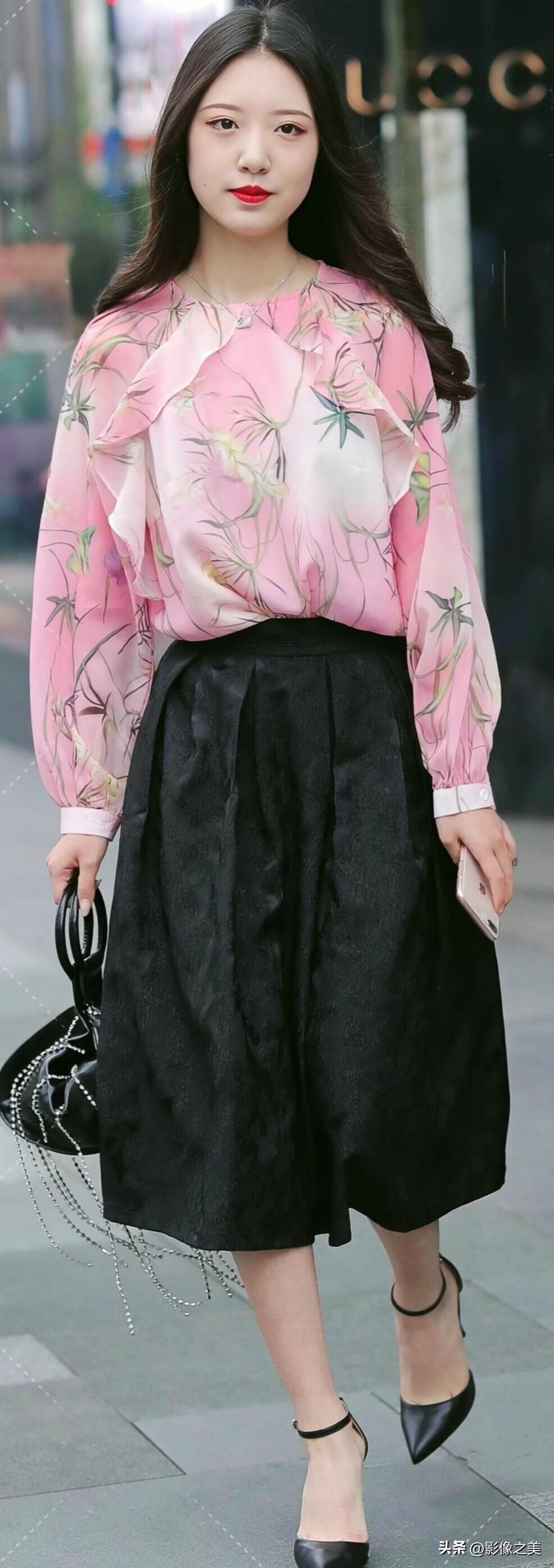 粉调印花雪纺衫搭配黑色提花裙，脚踩细高跟，手提链条包，温柔又不失气场，是春日街头