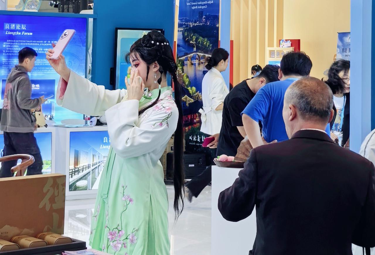 粉手机对着粉腮红，良渚玉棕样衣袖，还沾着西湖的风。大叔好像在说“姑娘的眉眼与良渚