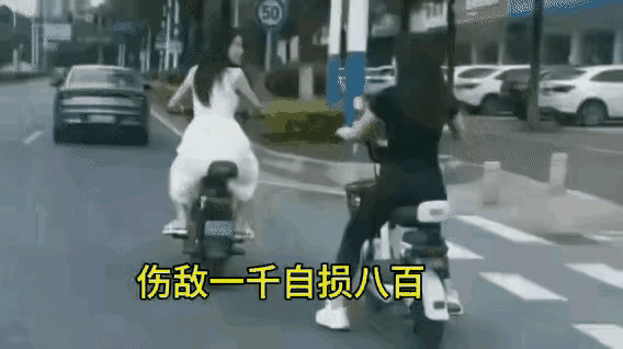 两个人都是骑电动车，何必相互为难呢？白衣服骑电动车的女子在前面。黑衣服骑电动车的