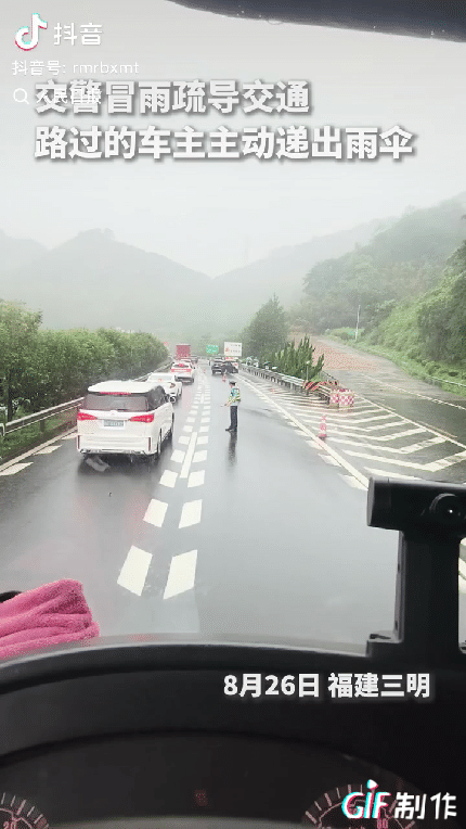 福建三明，一交警冒着大雨在路边疏导交通，一辆白车停了下来，本以为车出了什么事，结