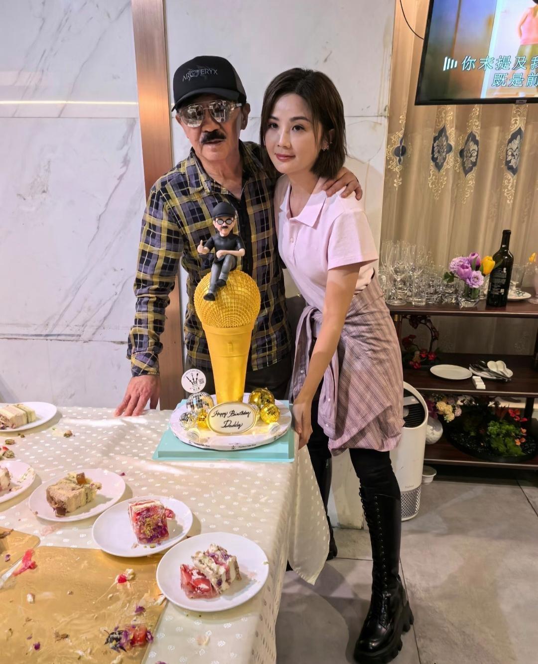 蔡卓妍为父亲蔡就胜庆祝生日，桌子上摆着一个大大的话筒蛋糕，蔡就胜戴着墨镜，留着小