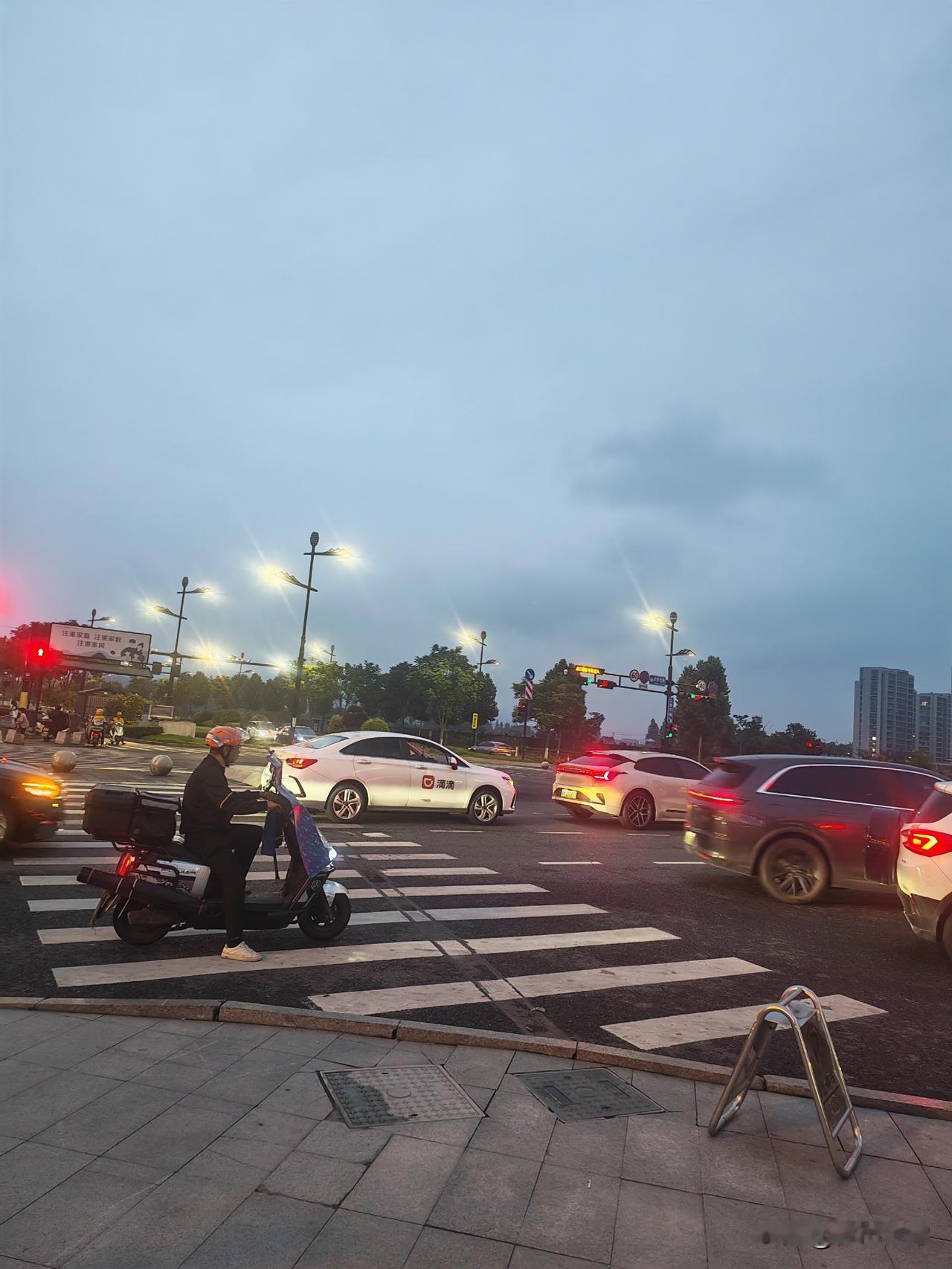 一家四口骑一辆两轮电瓶车，男人开车，女人坐后面。七八岁的女儿蹲在男人前面，三岁左