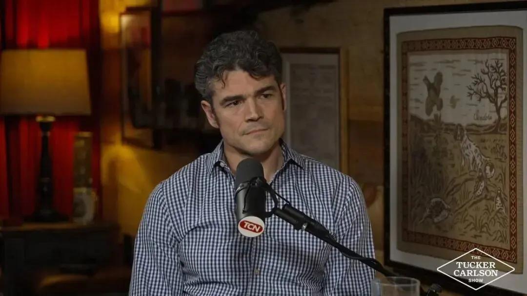 正在麦克风前接受采访的这位格子衫老哥，就是刚辞职的美国前国家反恐中心主任乔·肯特