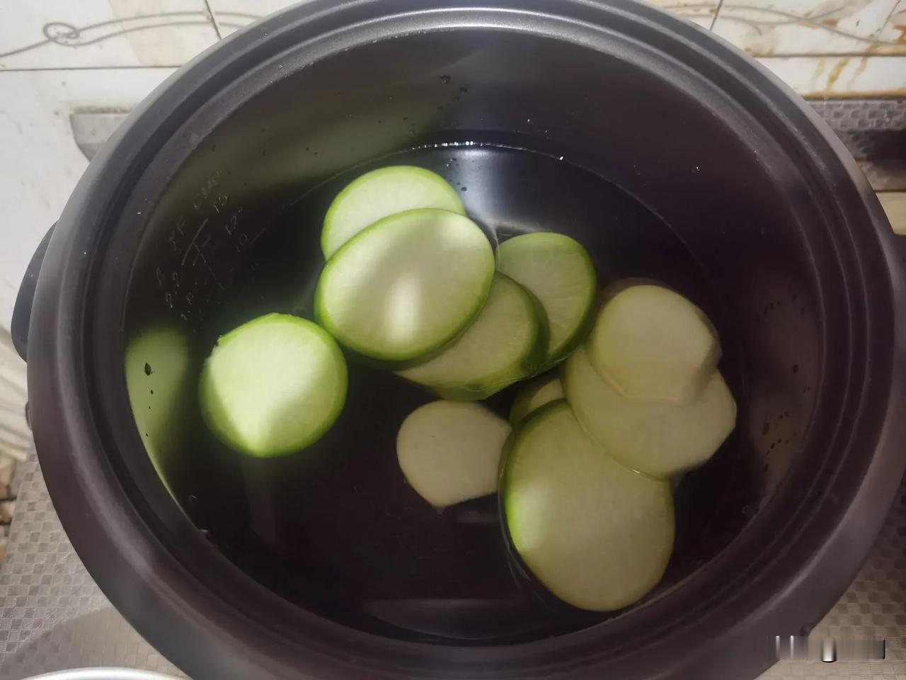 今日早餐，我是这样做的。先用电饭锅加适量的水，把萝卜切片煮一下，等萝卜熟后捞出，