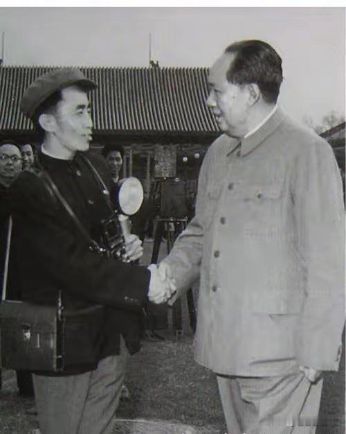 这是毛主席与专职厨师程汝明握手交谈的历史留影，拍摄于中南海院内，画面朴素亲切，见