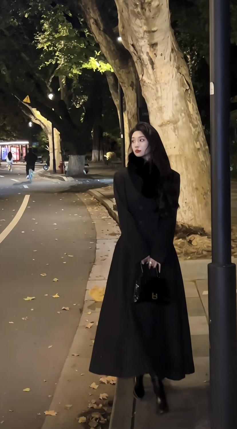 夜晚的街角，黑衣女子手拿香奈儿包包，优雅动人。高级包包女 香奈儿美女 简单的时尚