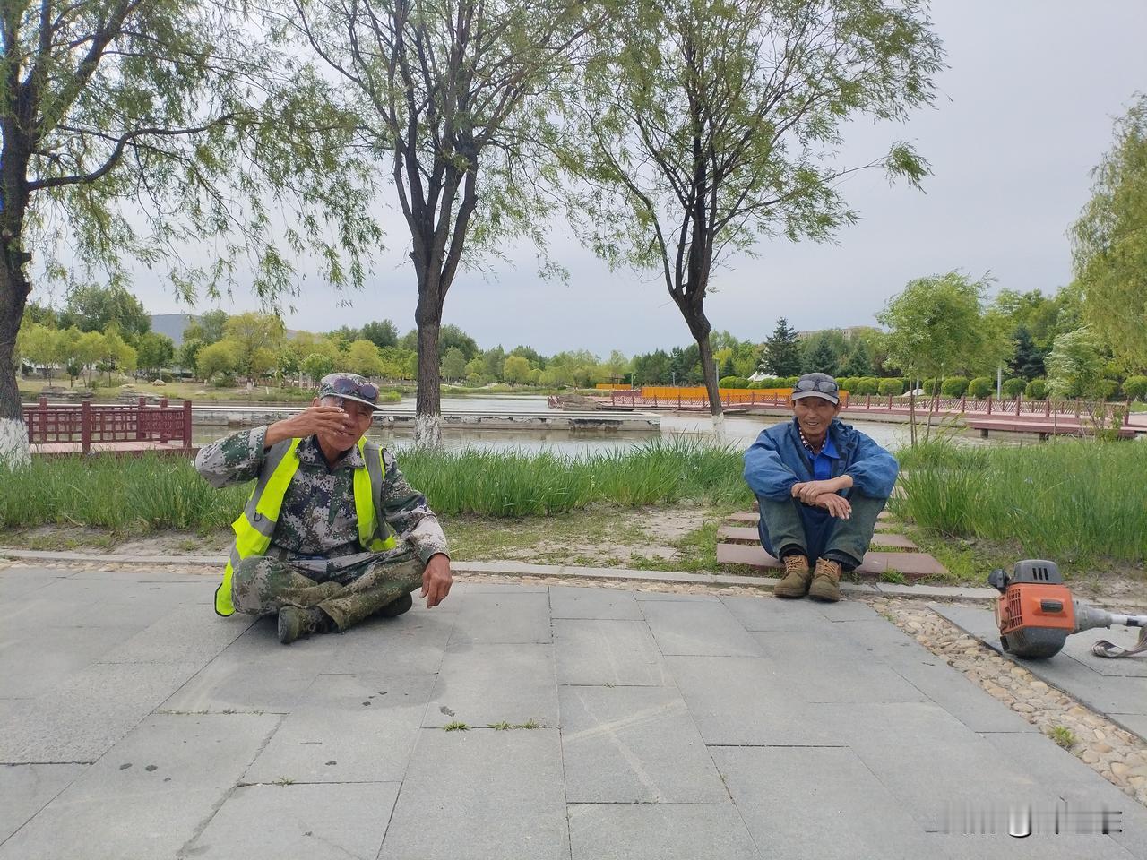 老头乐
年逾古稀修草坪，
玉露云霞益晶莹。
呑吐烟圈歇歇气，
请续句……
（河边