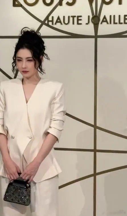张柏芝上身穿白色的单扣西装，这件衣服的设计很特别，能够让她展现出潇洒干练之美，她