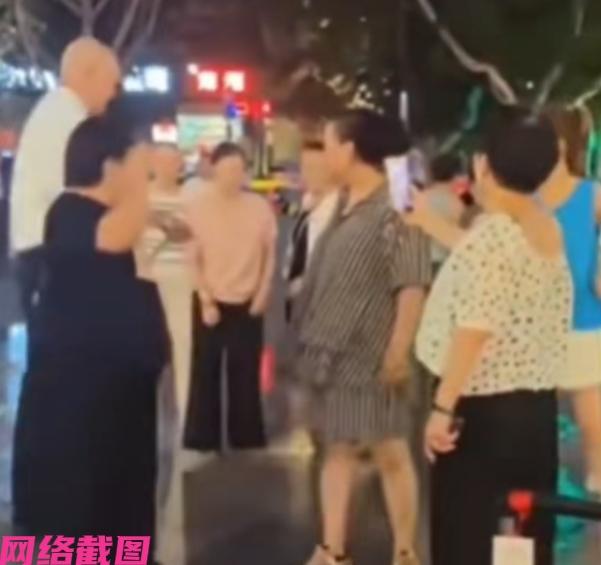 西安某商场门口晚上音乐响动，这是大妈们的广场舞时间到了，大妈们也正沉浸在广场舞的