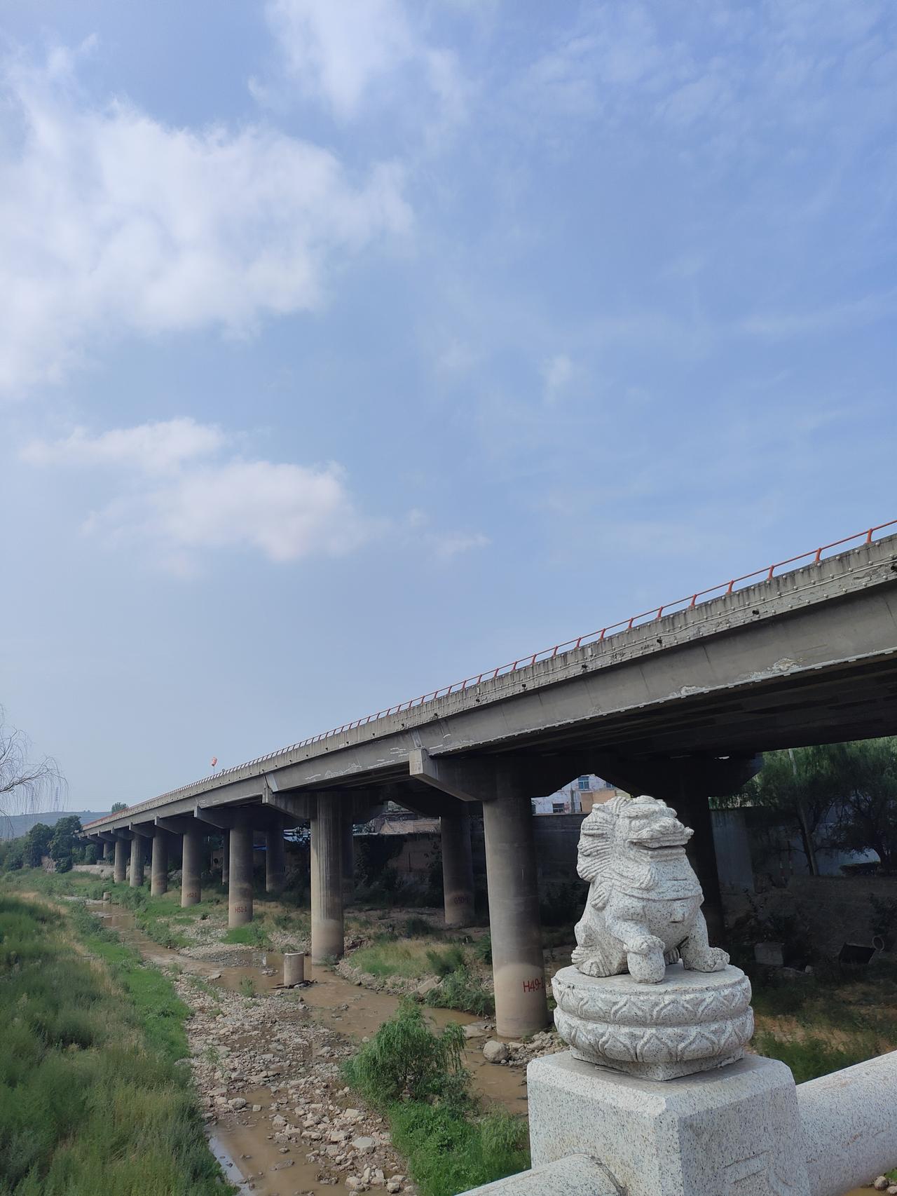 1. 石桥石狮静立，长桥横跨小河，流云漫过天际，小城夏日，安然寻常。
​2. 一
