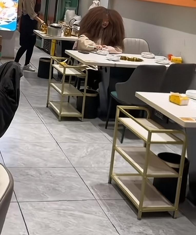 餐厅里有个大卷发的顾客在吃饭。在餐馆偶遇金毛狮王，发量惊人，很想知道她是怎么做到