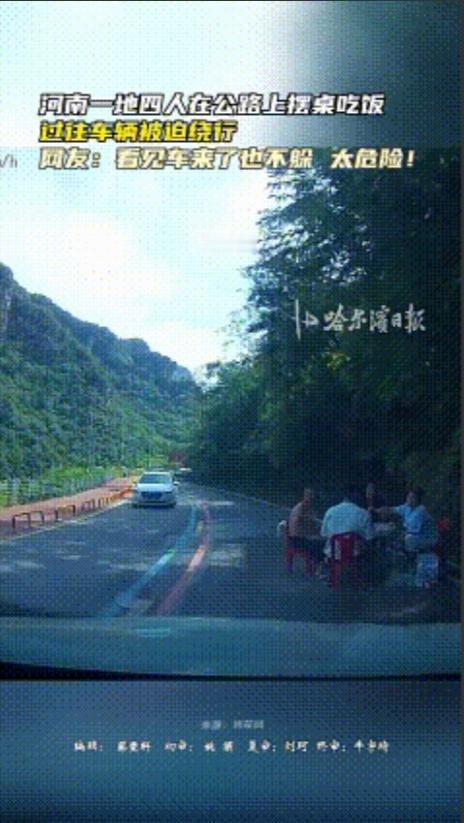 不要命了！河南某地的公路上，四人在车道中央摆桌聚餐，面对过往车辆毫不避让，淡定就