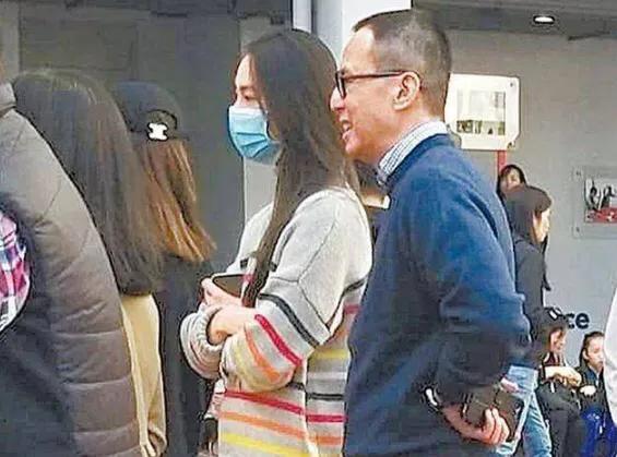 梁洛施精明地挽着一位男士参加婚宴，只露出男士的脸部。通过观察两人的身高差、体型和