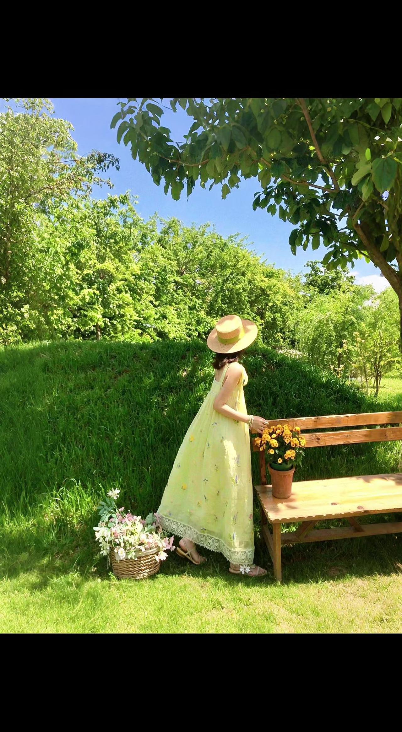 🌿草帽轻吻阳光，裙角兜住风的絮语💛。长椅旁花筐半满，像未写完的诗📖。时光在