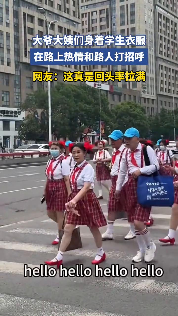 大爷大姨们身着学生衣服，在路上热情和路人打招呼。网友：这真是回头率拉满。
5月2