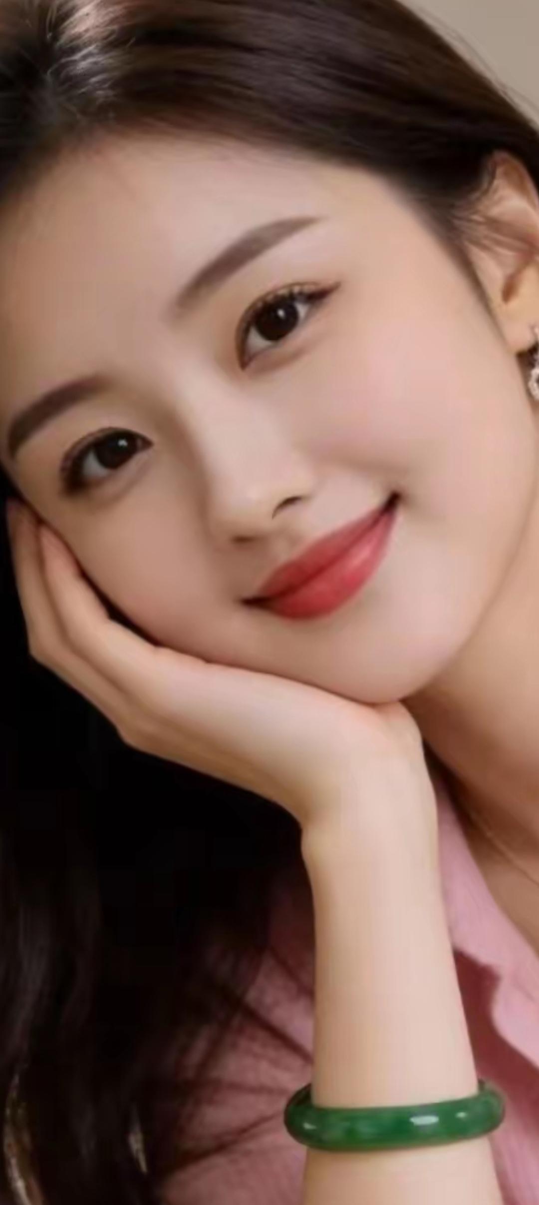 温柔甜美的微笑，绿玉手镯点缀，散发自然魅力。