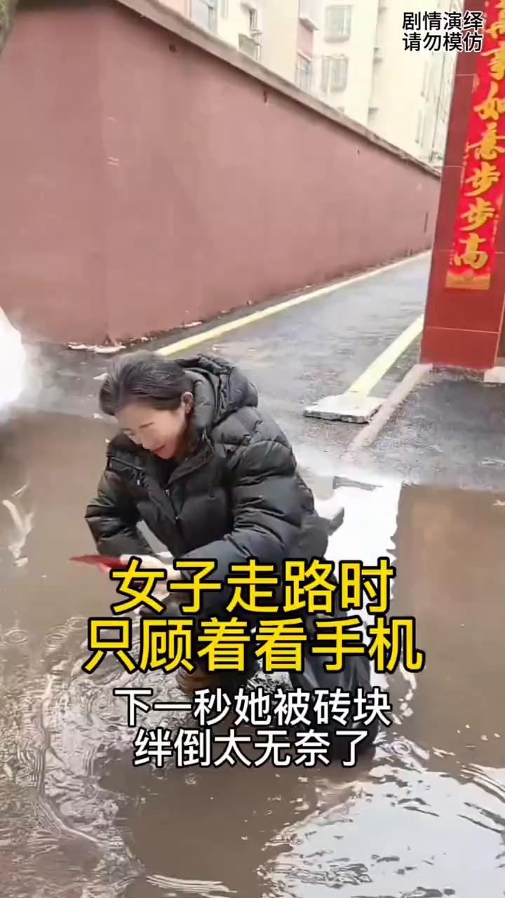 女子正走路时只顾着看手机，下一秒她被砖块绊倒太无奈了。
女子正走路时一直玩手机，