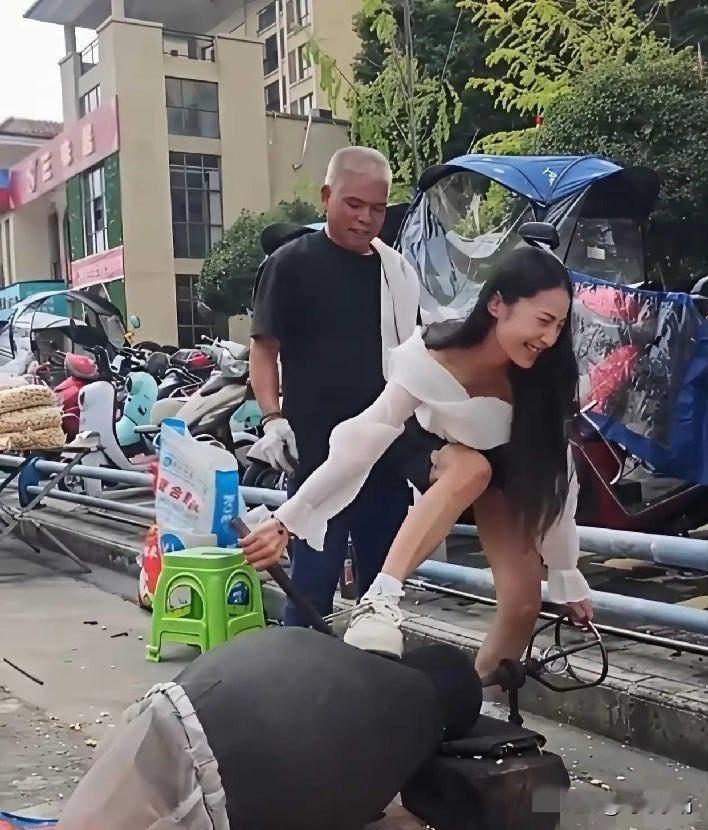 这位美女跌伤了，责任该怪谁呢？
大爷在路边摆摊，为他人炸爆米花。旁边的美女请求大