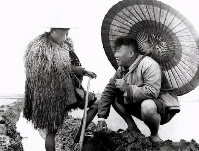 1965年，江苏。上世纪，扬州江都县小纪公社的干部深入田间查看涝情。他手撑破了的