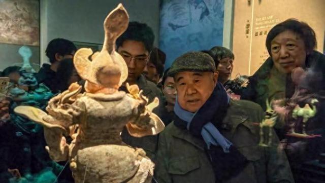 著名作家莫言近日再次现身天津大学，他戴着鸭舌帽，墨绿色羽绒服，灰色裤子，蓝色围脖